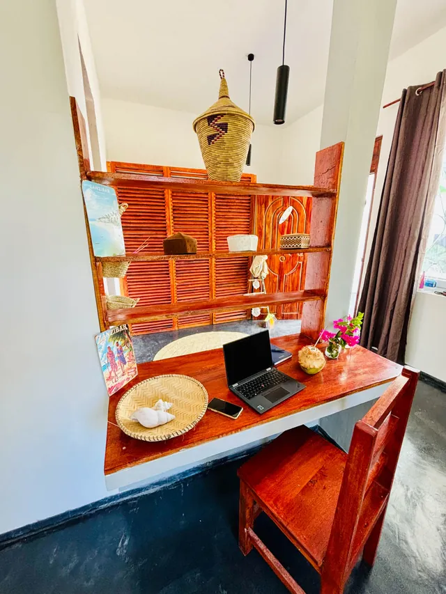 Desk with laptop and wooden shelf in the double bungalow