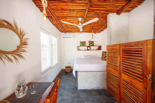 Bedroom in the house with wooden ceiling, ceiling fan and air conditioning