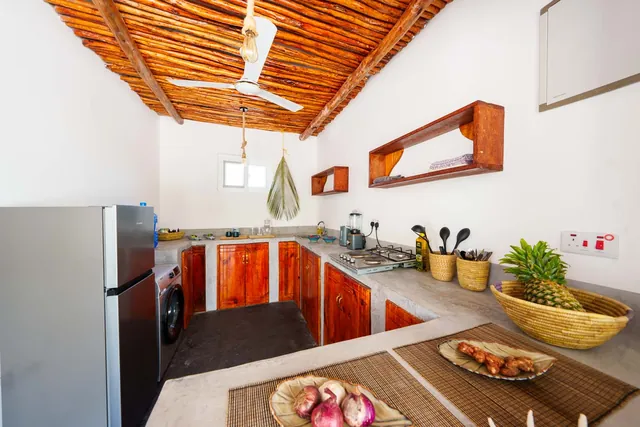 Kitchen in the house with fridge, wooden fronts and worktop